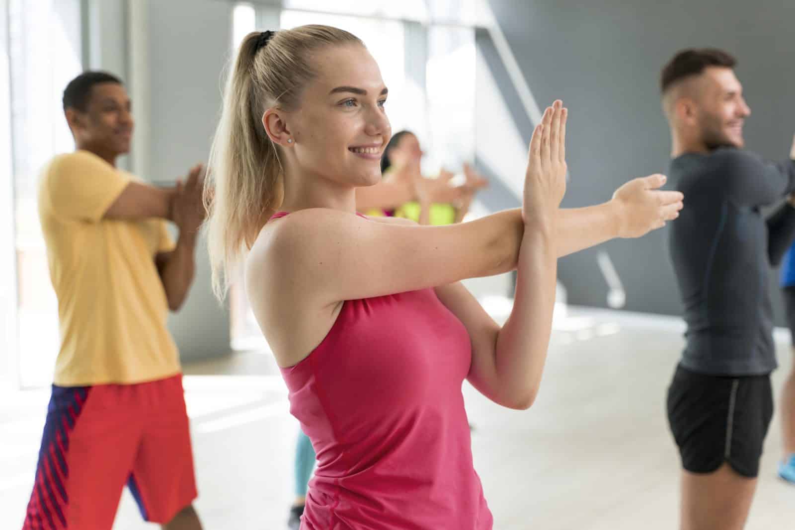 Femme souriante pendant un cours collectif de sport de danse